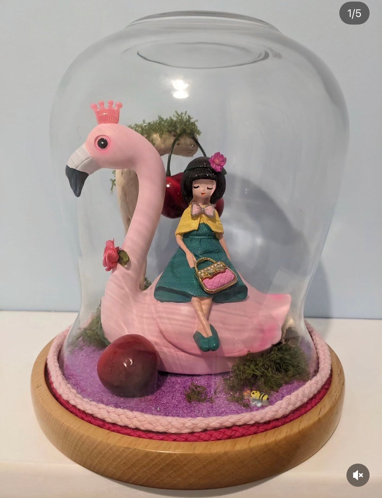 Création artisanale sous cloche : petite figurine sur un flamant rose, mousse et socle en bois